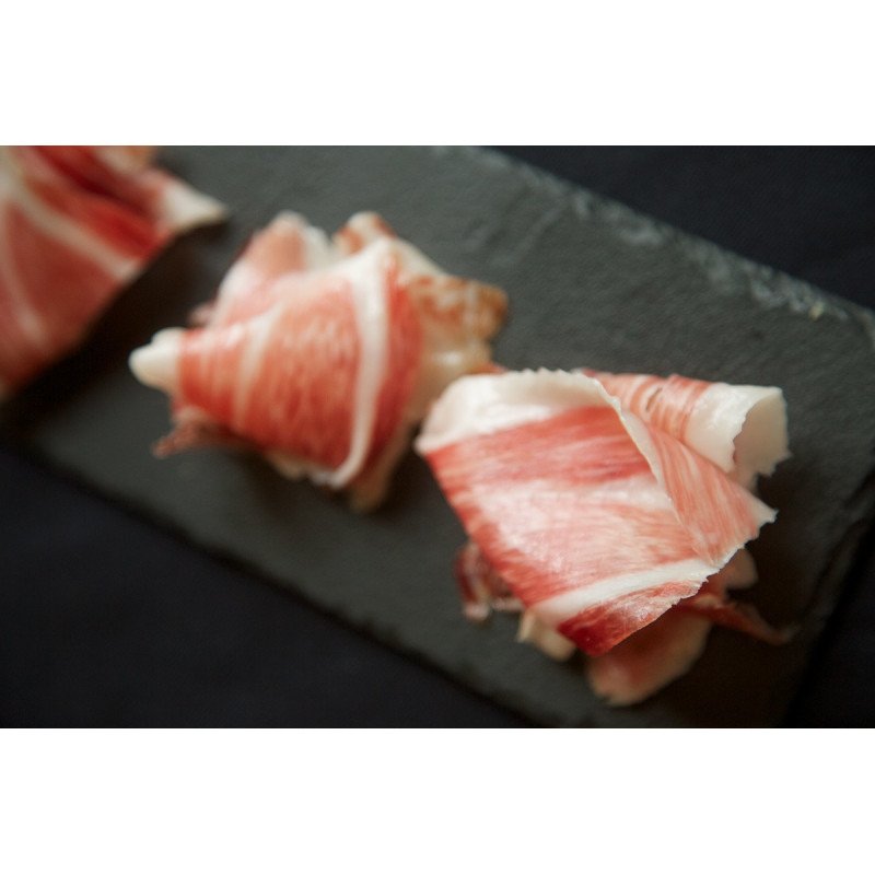 Jambon Ibérique 100%  Iberico de Bellota 5 Jotas en rosettes sur un plateau d'ardoise