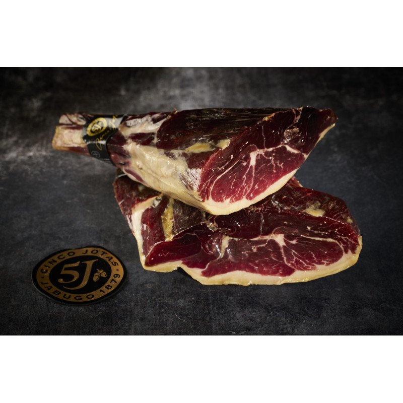 Deux Jambons Ibériques 100% Iberico de Bellota 5 Jotas présentées sur un plateau d'ardoise